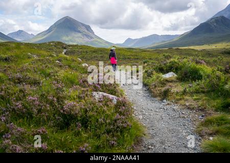 Eine Frau wandert einen Pfad in den Cuillin Mountains bei Sligachan, Isle of Skye, Schottland; Sligachan, Isle of Skye, Schottland Stockfoto