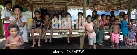 Lächelnde Kinder, die Daumen nach oben in einem Unterschlupf auf Kitava Island auf den Trobriand-Inseln, Papua-Neuguinea Stockfoto