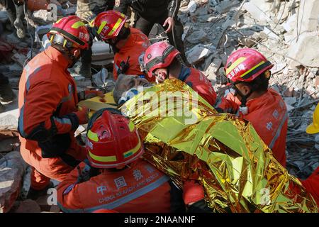 (230213) -- ANTAKYA, 13. Februar 2023 (Xinhua) -- chinesische und türkische Rettungskräfte transferieren einen Erdbebenüberlebenden in Antakya in der südlichen Provinz Hatay, T¨¹rkiye, 12. Februar 2023. Ein Überlebender wurde am Sonntagnachmittag, 150 Stunden nach dem Erdbeben in Antakya, T¨¹rkiye, von chinesischen und lokalen Rettungskräften aus den Trümmern gerettet. (Foto: Mustafa Kaya/Xinhua) Stockfoto