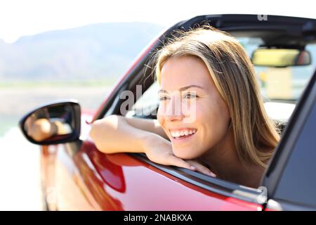 Fröhlicher Fahrer des Cabrios, der lacht und wegschaut Stockfoto