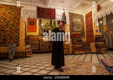 Ein Teppichverkäufer liefert seinen Pitch in einem Teppichgeschäft in Fes, Marokko; Fes, Marokko Stockfoto