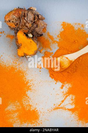 Kurkuma-Rhizome und Puder liegen flach auf Grau mit Kopierbereich Stockfoto
