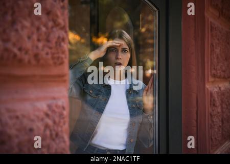 Eifersüchtige Frau, die ihren Ex-Freund im Freien ausspioniert Stockfoto