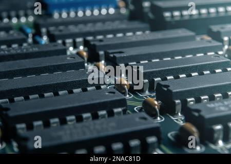 Nahaufnahme von Leiterplatten mit integrierten Schaltungen und vielen anderen passiven elektrischen Komponenten. Stockfoto