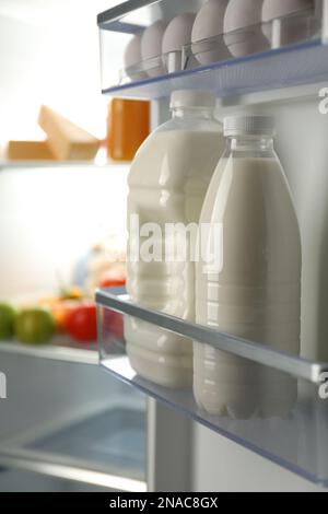 Gallone und eine Flasche Milch im Kühlschrank Stockfoto