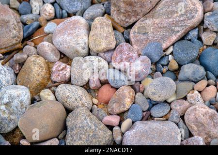 Hintergrund von Seesteinen. Steine verschiedener Formen, Größen und Farben am Meer, Nahaufnahme Stockfoto