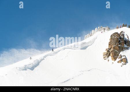 Skifahrer und Snowboarder wandern über dem Skigebiet Squaw Valley, Truckee, Squaw Valley, CA, USA Stockfoto