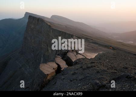 Die Mitglieder des Expeditionsteams stehen während ihrer Wanderung in Richtung Dark Star, einem Kalksteinhöhlensystem in Usbekistans Boysuntov-Gebirge, auf einer Klippe. Stockfoto