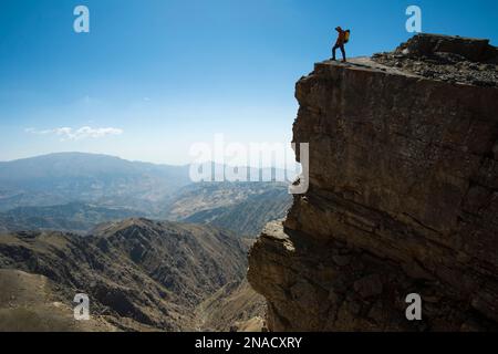 Ein Expeditionsteam steht während der Wanderung in Richtung Dark Star, einem Kalksteinhöhlensystem in Usbekistans Boysuntov-Gebirge, auf einer Klippe. Stockfoto