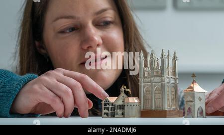 Scottish Gallery, Edinburgh, Schottland. Vicky Ambery-Smith Ausstellung von Silberwerken. Vicky Ambery-Smith ist eine Schmuck- und Silberdesignerin, die Architektur als Inspiration nutzt. Ihre Arbeit wird derzeit auf einer neuen Ausstellung gezeigt, die bis zum 25. Februar 2023 in der Scottish Gallery in Edinburghs Neustadt stattfindet. Das Bild zeigt Kirsty Sumerling aus der Scottish Gallery, mit einem Blick auf die vier aufwendigen Silberstücke des Gebäudes, einschließlich Shakespeare Globe Theatre (links), Magdalen Tower Box, 2015 (Mitte) und Scottish Doocot Lapel Pin - inspiriert von Bowerbutts II, 2018 Picture Phil Wilki Stockfoto