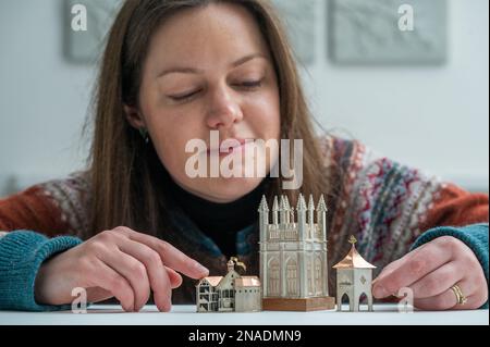 Scottish Gallery, Edinburgh, Schottland. Vicky Ambery-Smith Ausstellung von Silberwerken. Vicky Ambery-Smith ist eine Schmuck- und Silberdesignerin, die Architektur als Inspiration nutzt. Ihre Arbeit wird derzeit auf einer neuen Ausstellung gezeigt, die bis zum 25. Februar 2023 in der Scottish Gallery in Edinburghs Neustadt stattfindet. Das Bild zeigt Kirsty Sumerling aus der Scottish Gallery, mit einem Blick auf die vier aufwendigen Silberstücke des Gebäudes, einschließlich Shakespeare Globe Theatre (links), Magdalen Tower Box, 2015 (Mitte) und Scottish Doocot Lapel Pin - inspiriert von Bowerbutts II, 2018 Picture Phil Wilki Stockfoto