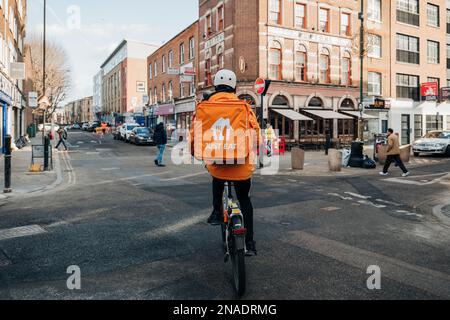 London, Großbritannien - 09. Februar 2023: Essen Sie einfach einen Lieferfahrer auf einer Straße im Osten Londons. Just Eat ist ein Unternehmen, das es ermöglicht, Lebensmittel aus der Ruhe zu liefern Stockfoto