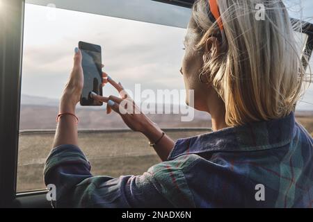 Frau, die ein Foto vom Grand Canyon durch das Autofenster macht Stockfoto