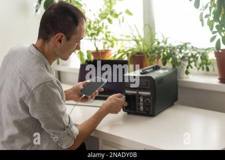 Ein Mann verwendet eine tragbare Ladestation Stockfoto