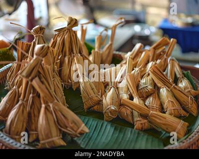 Traditionelles thailändisches Essen, glühender Reis gedünstet mit Bananenwickelung, Bananenblatt oder Nipa-Palmenblatt ( Khao Tom Mat ) Thai-Dessert. Stockfoto