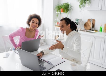 afroamerikanische Freiberufler benutzen Laptops in der Nähe von Kaffee in der Küche Stockfoto