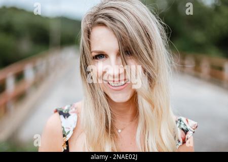 Lässiges Porträt einer lächelnden jungen Frau im Freien Stockfoto