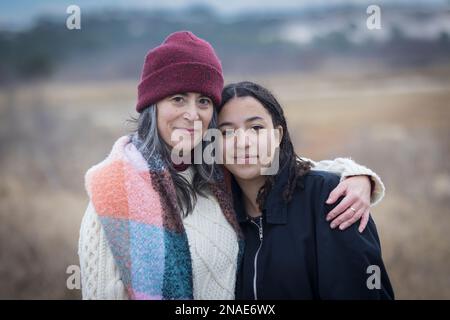 Porträt einer weißen Mutter mit birassischer Teenager-Tochter in der Natur Stockfoto