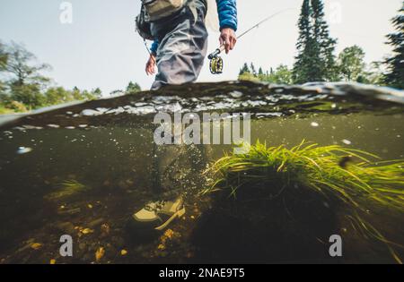 Unterwasserfoto eines Mannes, der auf dem Grund des Flusses läuft Stockfoto