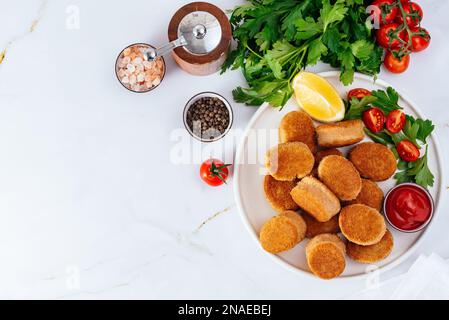 Chicken Nuggets auf einem Teller mit leichtem Hintergrund, Tomatensoße, Stockfoto