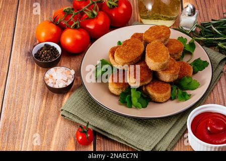 Chicken Nuggets auf einem Teller mit Sauce, Holzauflage Stockfoto