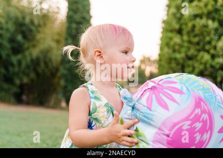 Zwei Jahre altes Baby spielt Ballons auf dem Gras, Sommerparty Stockfoto