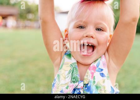 Zwei Jahre altes Baby spielt Ballons auf dem Gras Stockfoto