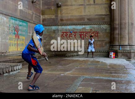 Kinder, die Cricket auf den Ghats spielen; Varanasi, Indien Stockfoto