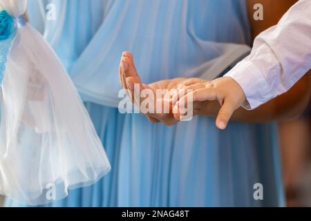 Jungs Hand auf Mütter Hand in der Kirche. Taufe für Kinder. Hochwertiges Foto Stockfoto