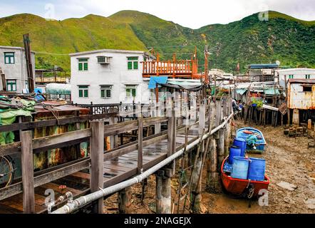 Tai O Fischerdorf, Lantau Island. Primitive Blechhäuser stehen auf Pfählen, an denen Fischerboote festgemacht sind. Eine beliebte Touristenattraktion in Stockfoto