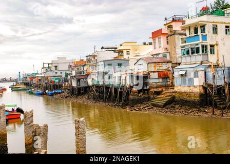 Tai O Fischerdorf, Lantau Island. Primitive Blechhäuser stehen auf Pfählen, an denen Fischerboote festgemacht sind. Eine beliebte Touristenattraktion in Stockfoto