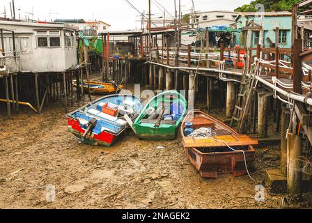 Tai O Fischerdorf, Lantau Island. Primitive Blechhäuser stehen auf Pfählen, an denen Fischerboote festgemacht sind. Eine beliebte Touristenattraktion in Stockfoto