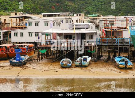 Tai O Fischerdorf, Lantau Island. Primitive Blechhäuser stehen auf Pfählen, an denen Fischerboote festgemacht sind. Eine beliebte Touristenattraktion in Stockfoto