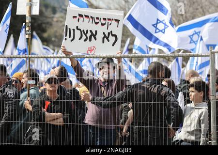 Jerusalem, Israel. 13. Februar 2023. Israelis halten während eines Protests gegen die rechte Regierung Flaggen und Plakate. Kredit: Ilia Yefimovich/dpa/Alamy Live News Stockfoto