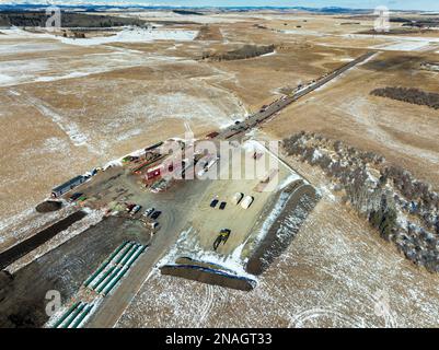 Luftaufnahme des Rohrleitungsbaus auf einem schneebedeckten Feld westlich von Calgary in Alberta, Kanada Stockfoto