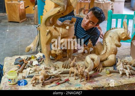 Kunsthandwerker repariert Risse im Kopalholz eines Alebrije-Tieres nach dem Trocknen in einer Werkstatt in San Martin Tilcajete, Oaxaca, Mexiko. Risse sind es Stockfoto