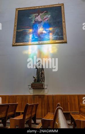 Das Innere der Kirche des Heiligen Franziskus von Assisi in der historischen Stadt Oaxaca, Mexiko. Farbiges Licht aus einem Buntglasfenster beleuchtet die Wand A. Stockfoto