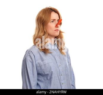 Frau mit Wäschespin auf weißem Hintergrund. Das Runny-Nose-Konzept Stockfoto