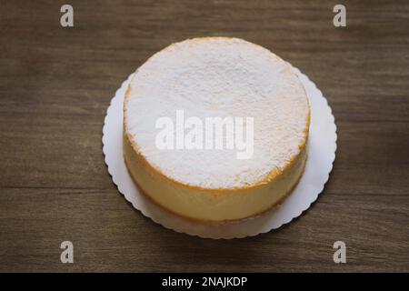 Ganze Käsekuchen oder deutsche Käsecremesorte oder Torte auf Rustikaler Holztisch Stockfoto