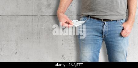 Mittelteil des Mannes, der seine leeren Taschen von innen nach außen dreht, kein Geld hat und pleite Konzept ist Stockfoto