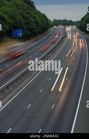 Auf der M40 in Buckinghamshire, Großbritannien, kommt es zu rasanten Fahrten. Langsame Verschlusszeiten und Fotos mit langer Belichtung erzeugen Lichtstrecken und Streifen. Stockfoto