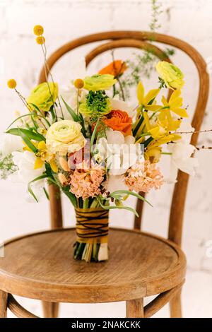 Ein Blumenstrauß in einer rosafarbenen Box steht auf schwarzgrauem Hintergrund. Die Blumen sind weiß, rosa, cremefarben, in verschiedenen Größen. Grußkarte mit dem H. Stockfoto