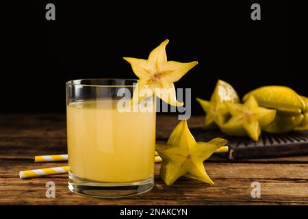 Köstlicher Karambolasaft im Glas auf einem Holztisch Stockfoto