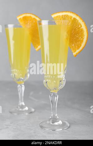 Gläser Mimosa-Cocktail mit Garnierung auf Marmortisch Stockfoto
