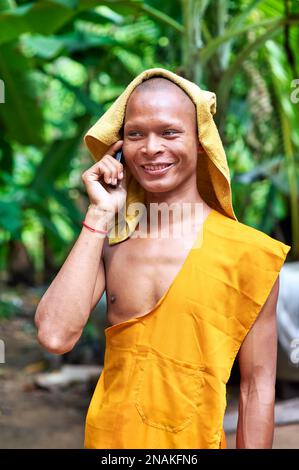 Ein lächelnder Mönch spricht auf einem Mobiltelefon in Siem Reap. Angkor. Kambodscha Stockfoto