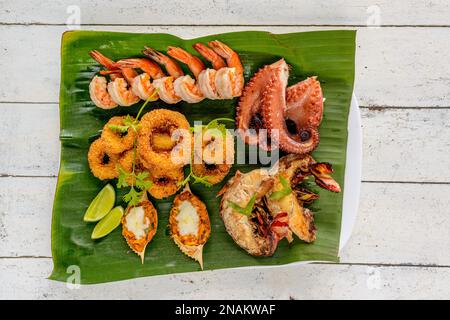 Gemischte Meeresfrüchte, Gebacken. Mit Garnelen, Tintenfisch, Tintenfisch, Hummer und Krabben auf Bananenblättern. Brasilianische Gastronomie. Stockfoto