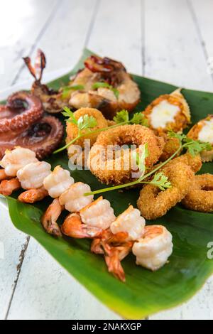 Gemischte Meeresfrüchte, Gebacken. Mit Garnelen, Tintenfisch, Tintenfisch, Hummer und Krabben auf Bananenblättern. Brasilianische Gastronomie. Stockfoto