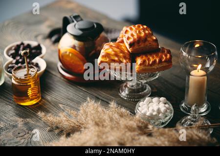 Hausgemachtes Gebäck auf einem wunderschön servierten Tisch, dekoriert in rustikalem Stil. Gemütliches Zuhause, Teezeit, kulinarischer Hintergrund Stockfoto