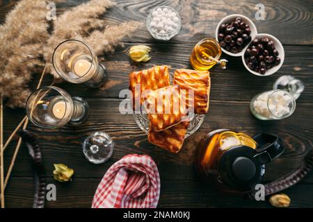 Hausgemachtes Gebäck auf einem wunderschön servierten Tisch, dekoriert in rustikalem Stil. Gemütliches Zuhause, Teezeit, kulinarischer Hintergrund Stockfoto