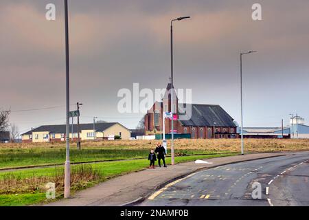 Grimmige DrumChapel Wohnsiedlung Armut erschossen alleinerziehende Eltern, die an der Bushaltestelle auf den Bus warten Stockfoto